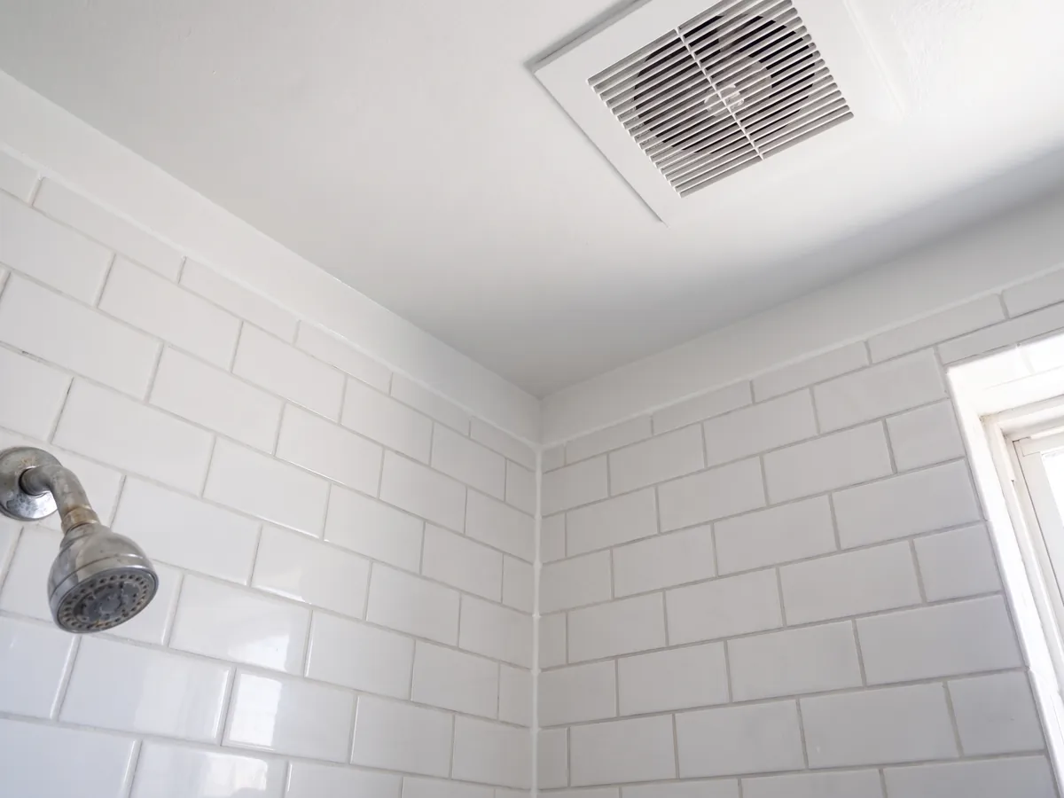 After mold remediation in Gettysburg, PA: the same bathroom ceiling repainted white with clean grout and fresh caulk